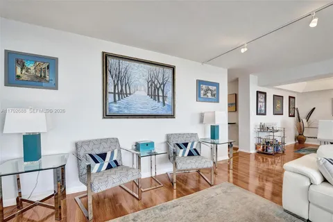 a living room with furniture and a dining table with wooden floor