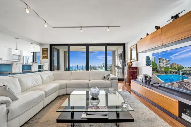 a living room with furniture a flat screen tv and a large window