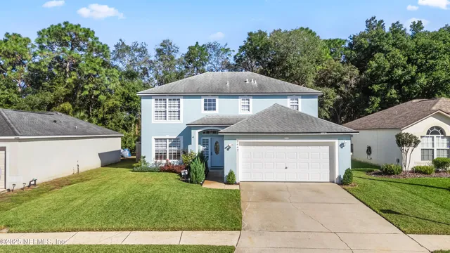 a front view of a house with a yard and garage