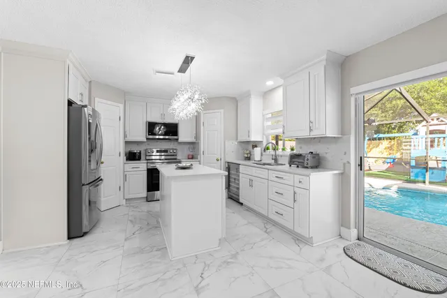 a kitchen with white cabinets and appliances