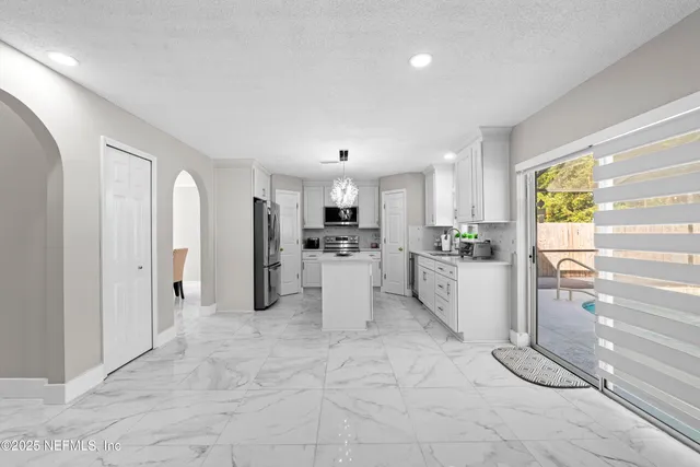 a view of a kitchen with refrigerator and microwave