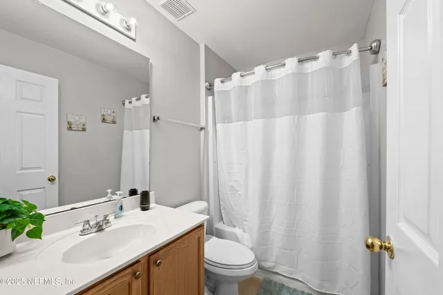 a spacious bedroom with a bed and a flat screen tv