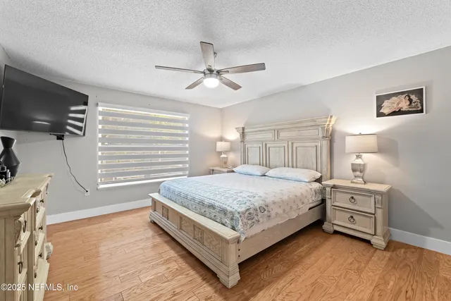 a bedroom with a large bed and a chandelier