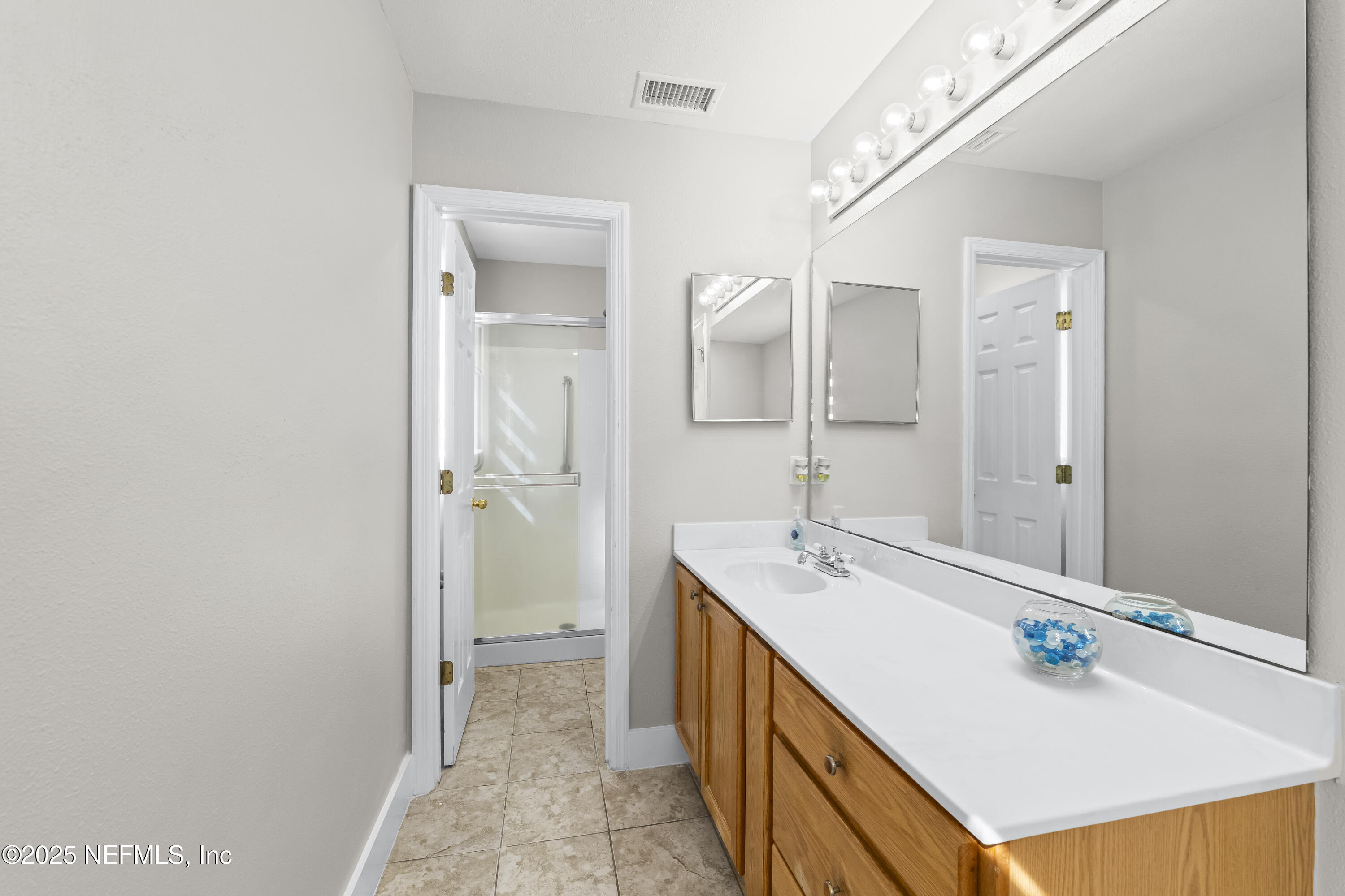 3447 Caroline Ridge Lane East Jacksonville, FL 32225 - Photo 31 of 44 a bathroom with a sink a mirror and a shower