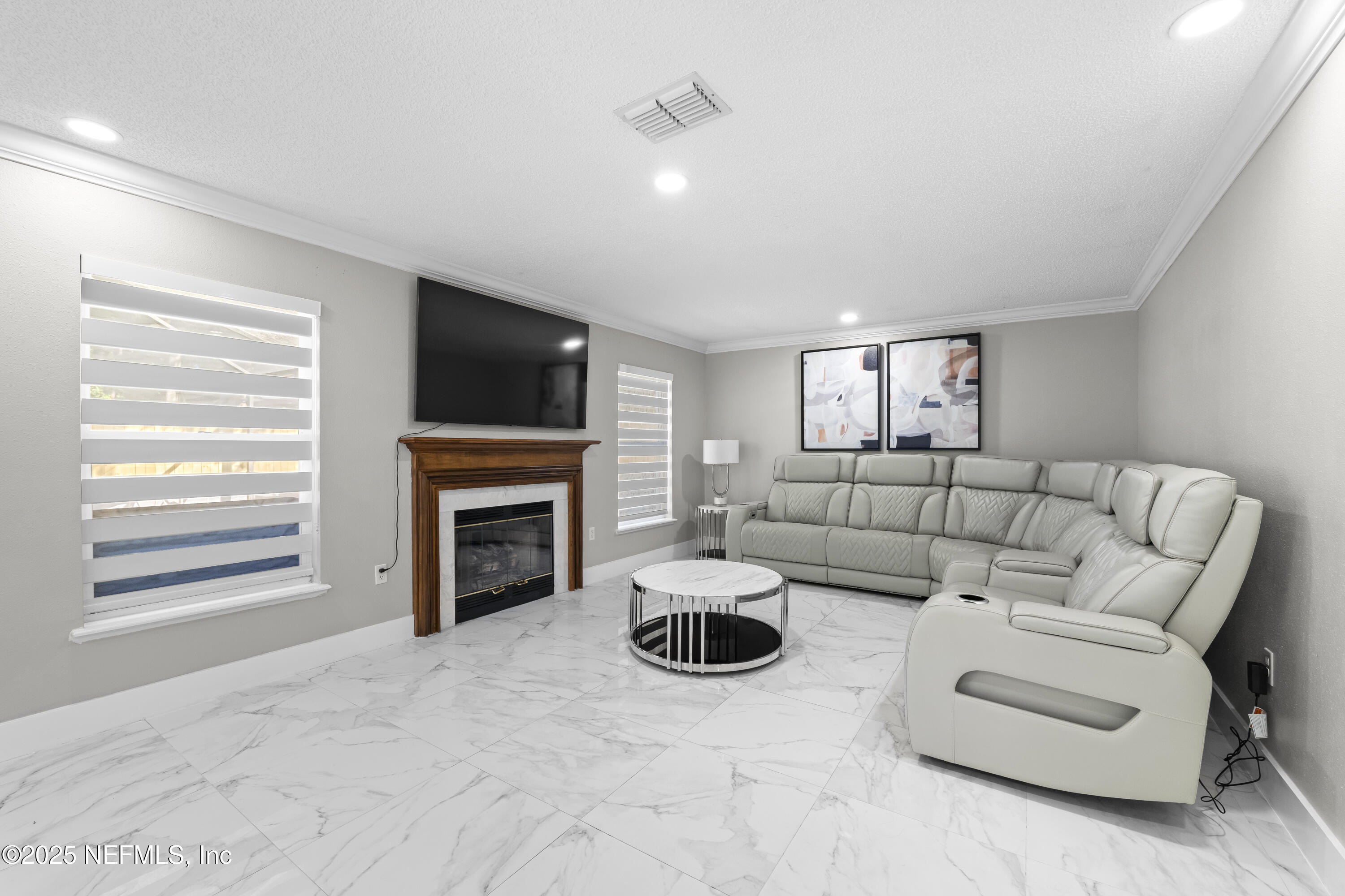 3447 Caroline Ridge Lane East Jacksonville, FL 32225 - Photo 6 of 44 a living room with furniture a fireplace and a flat screen tv