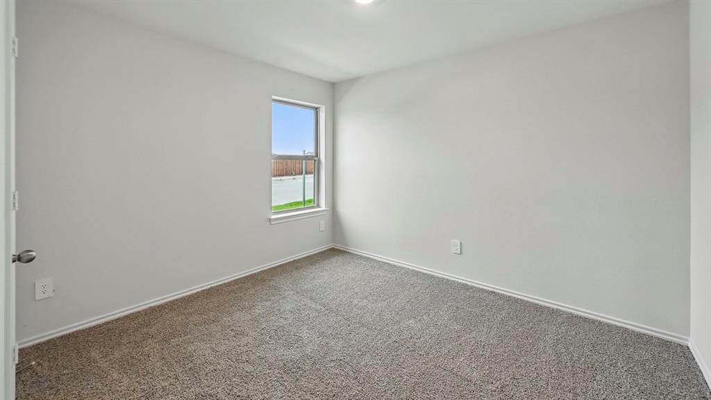 1908 Freeman Street Tyler, TX 75704 - Photo 24 of 30 Neutral tone walls with white trim, gray textured carpet flooring, and a single window