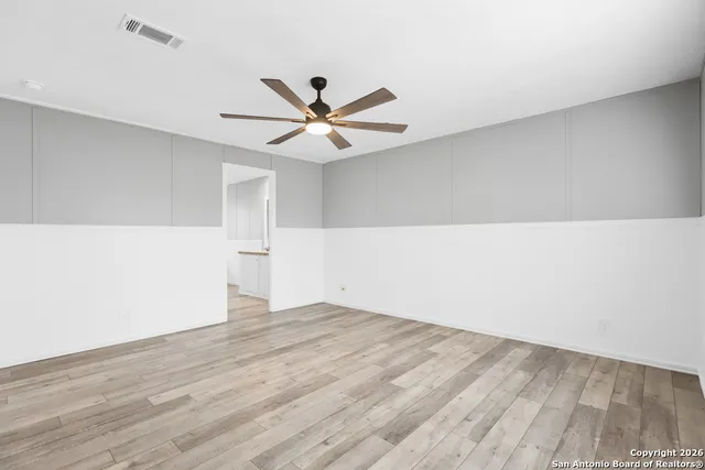 a view of an empty room with wooden floor