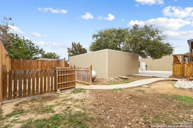 a view of a backyard with wooden fence