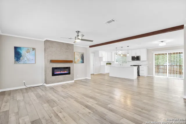 a view of an empty room with a window and fireplace