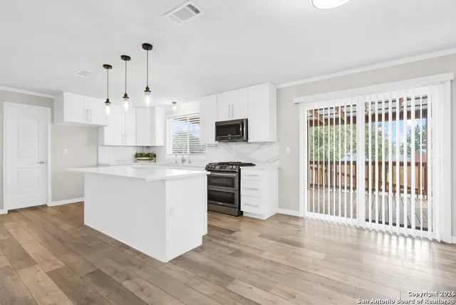 a kitchen with white cabinets and appliances