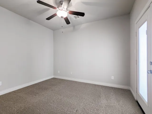 an empty room with a window and a fan