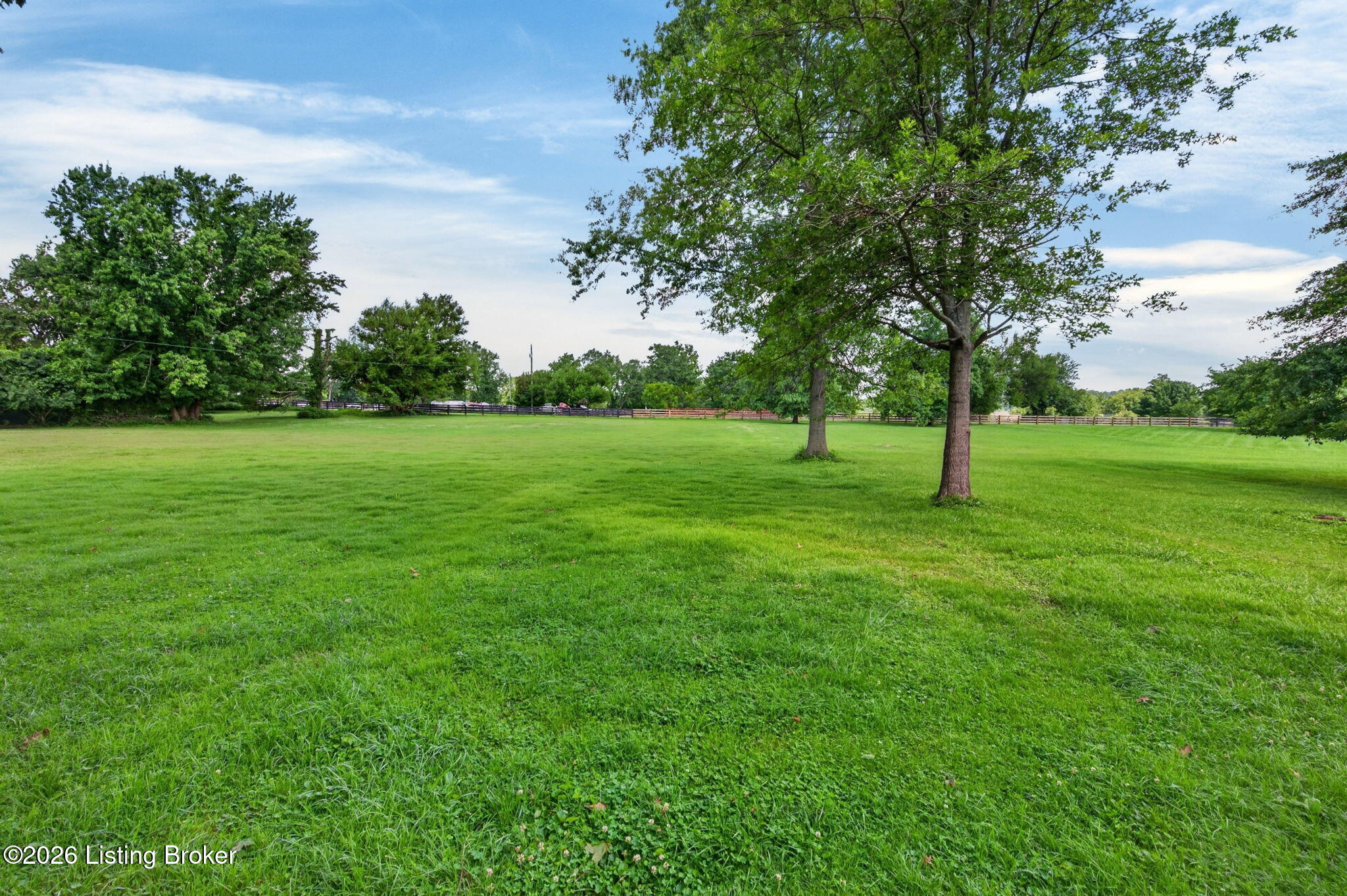 2104 North Rose Island Road Prospect, KY 40059 - Photo 56 of 57 Open, level pasture bordered by wood fencing stretches out beyond the property's tree line
