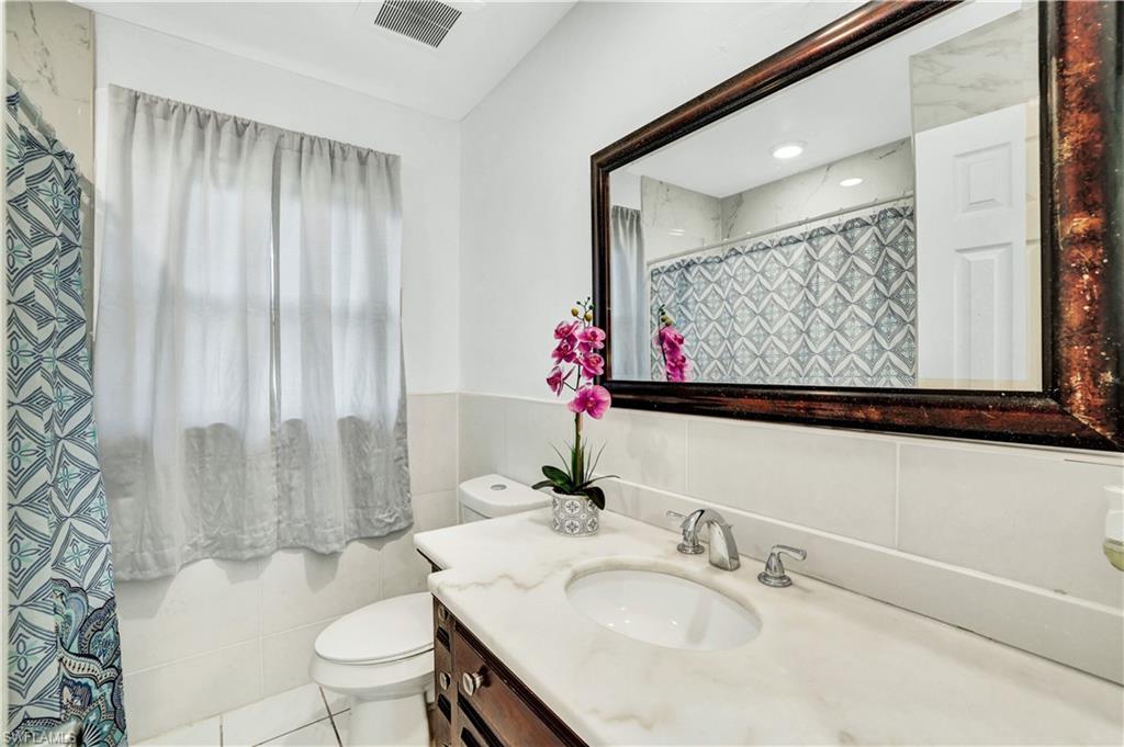 2540 47th Terrace Southwest Naples, FL 34116 - Photo 13 of 17 a bathroom with a sink vanity mirror and toilet