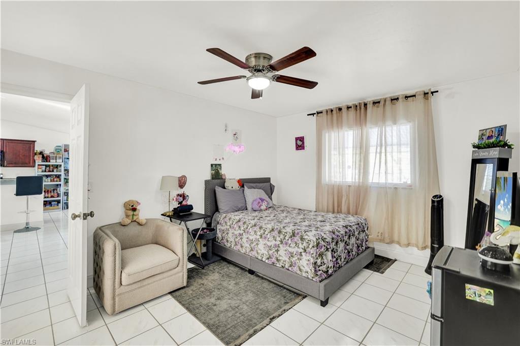 2540 47th Terrace Southwest Naples, FL 34116 - Photo 14 of 17 a bedroom with a bed couch and a window