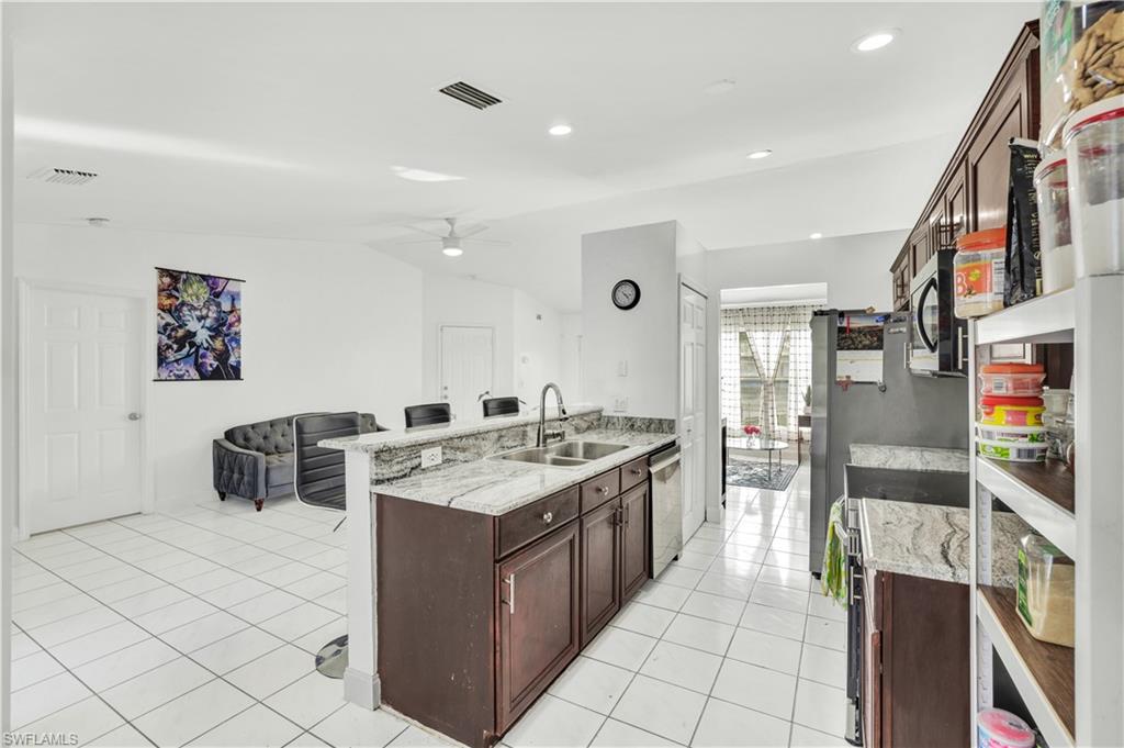 2540 47th Terrace Southwest Naples, FL 34116 - Photo 9 of 17 a kitchen with a sink a stove and a refrigerator