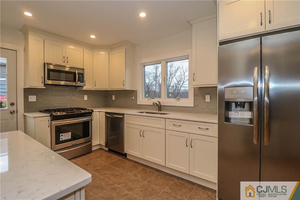 355 Chain O' Hills Road Colonia, NJ 07067 - Photo 11 of 25 a kitchen with stainless steel appliances granite countertop a refrigerator a stove a sink and a microwave