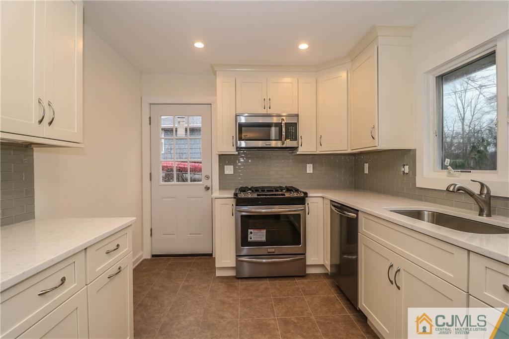 355 Chain O' Hills Road Colonia, NJ 07067 - Photo 12 of 25 a kitchen with granite countertop white cabinets stainless steel appliances and sink