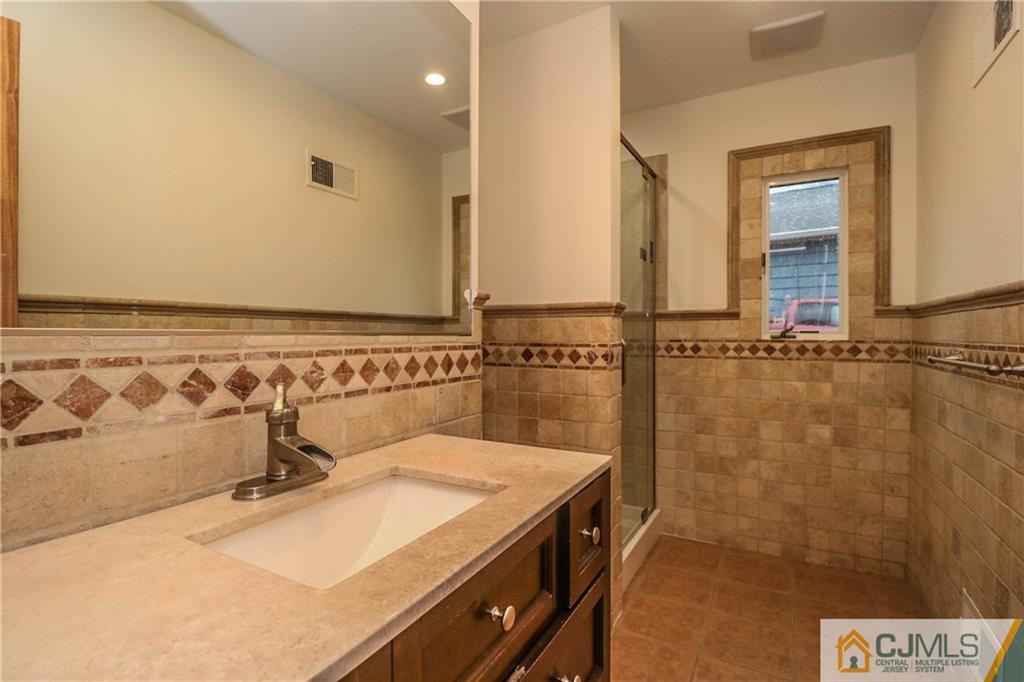 355 Chain O' Hills Road Colonia, NJ 07067 - Photo 17 of 25 a bathroom with a sink and a mirror