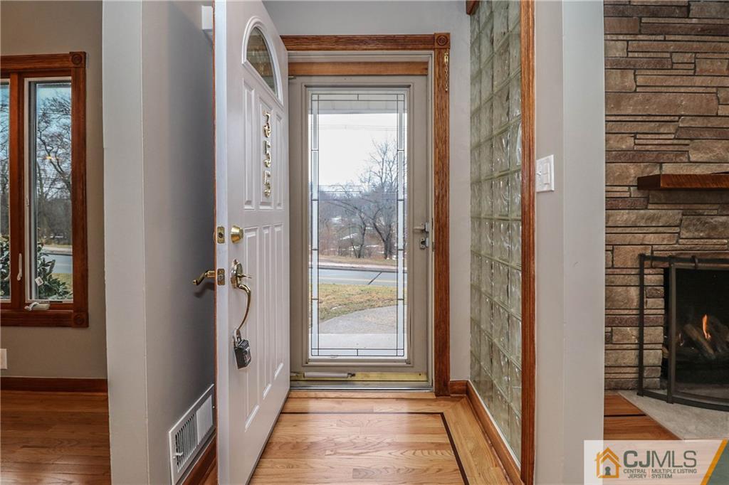 355 Chain O' Hills Road Colonia, NJ 07067 - Photo 5 of 25 a view of a hallway with wooden floor and a livingroom with windows