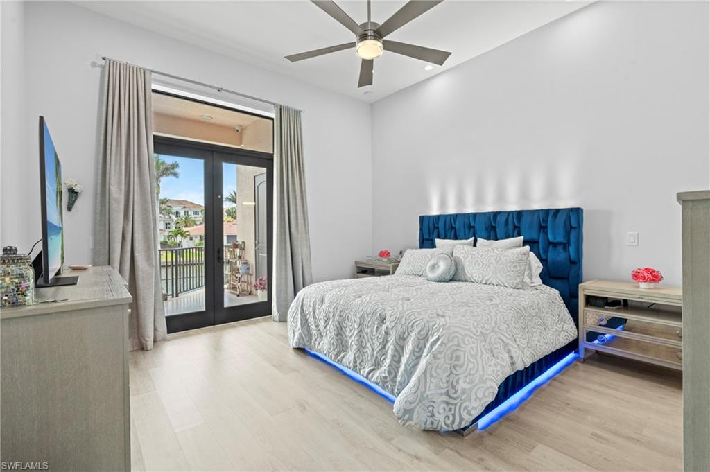 388 Pine Avenue Naples, FL 34108 - Photo 16 of 42 a spacious bedroom with a bed and a chandelier