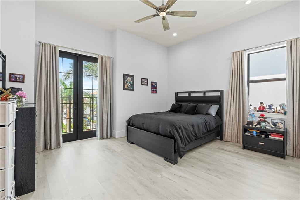 388 Pine Avenue Naples, FL 34108 - Photo 28 of 42 a bedroom with a large bed and a chandelier