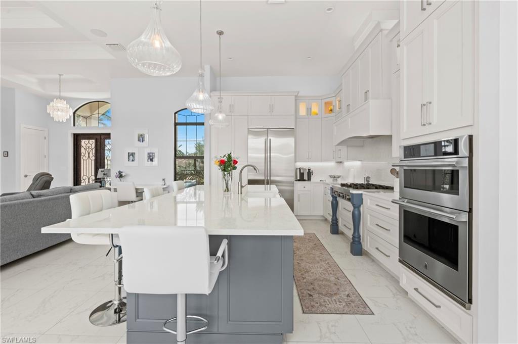 388 Pine Avenue Naples, FL 34108 - Photo 41 of 42 a large kitchen with granite countertop a stove a sink a dining table and chairs