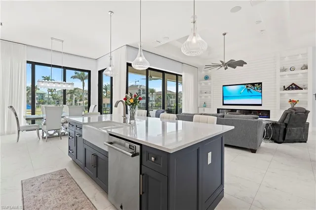 a large kitchen with granite countertop a stove a sink a dining table and chairs