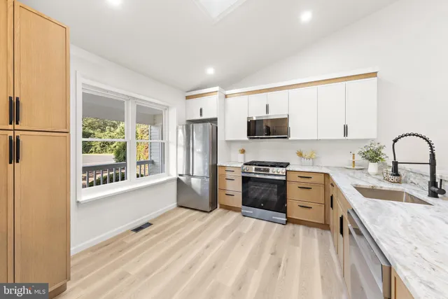 a large kitchen with kitchen island granite countertop a sink stainless steel appliances and cabinets