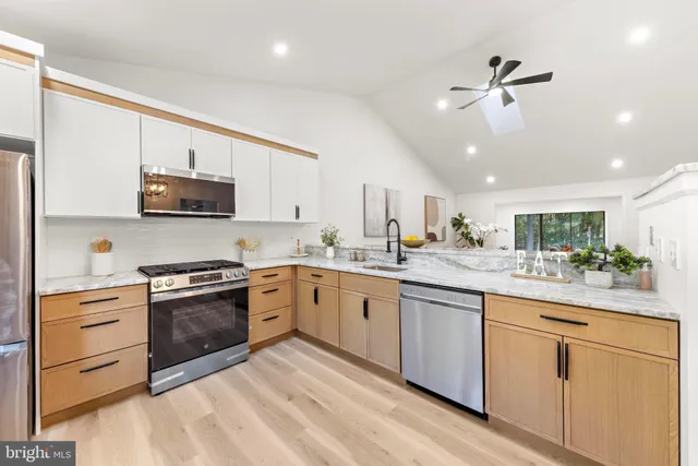 a kitchen with granite countertop cabinets stainless steel appliances and a sink