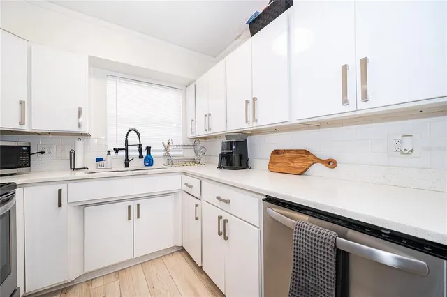 a kitchen with white cabinets and white appliances