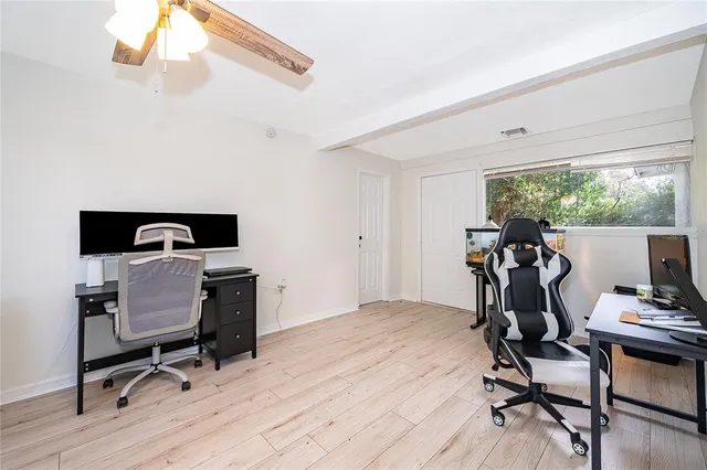 a view of a workspace with furniture and a window