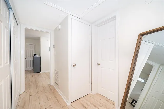 a view of a hallway with wooden floor and closet area