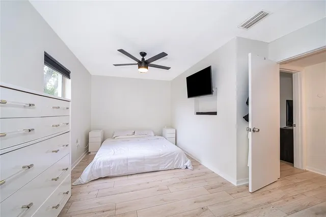 a bedroom with a bed and a flat tv screen in it