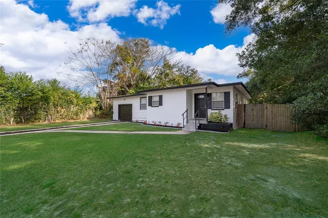 a view of a house with backyard and a tree