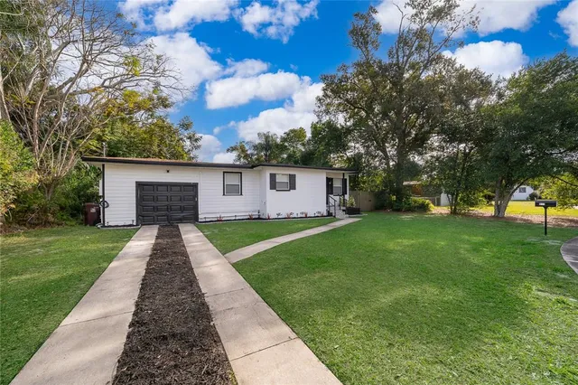 a front view of a house with a yard and trees