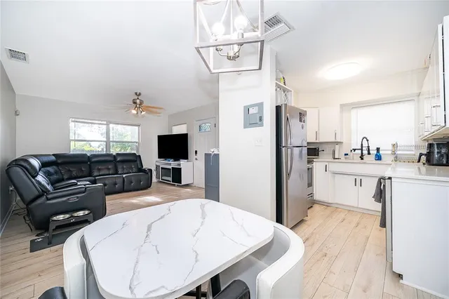 a living room with furniture a flat screen tv and kitchen view