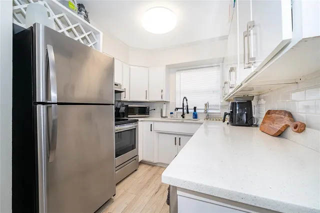 a kitchen with refrigerator and cabinets