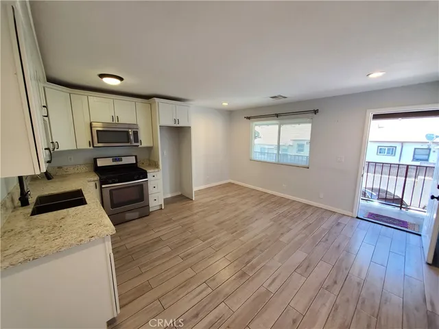 a kitchen with granite countertop a stove a sink and a refrigerator