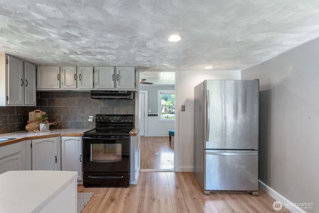 a kitchen with a refrigerator stove and wooden cabinets