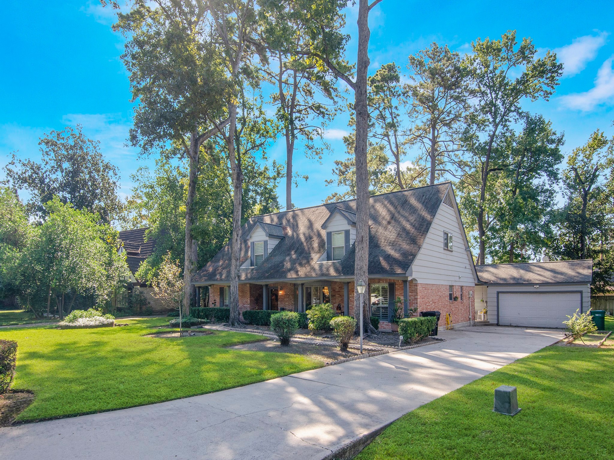 532 Raleigh Drive Conroe, TX 77302 - Photo 34 of 40 This view highlights the front of the home, covered breezeway leading to the two-car garage, and the long driveway surrounded by a well-kept front yard.