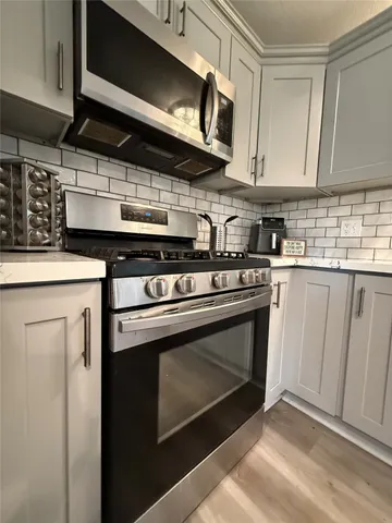 a kitchen with stainless steel appliances granite countertop a stove microwave and sink