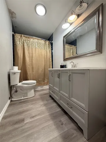 a bathroom with a double vanity sink a mirror and a toilet