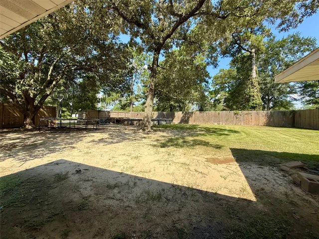 a view of yard with swimming pool and trees