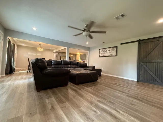 a living room with furniture and a ceiling fan
