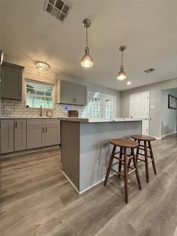 a kitchen with stainless steel appliances granite countertop table chairs sink and cabinets