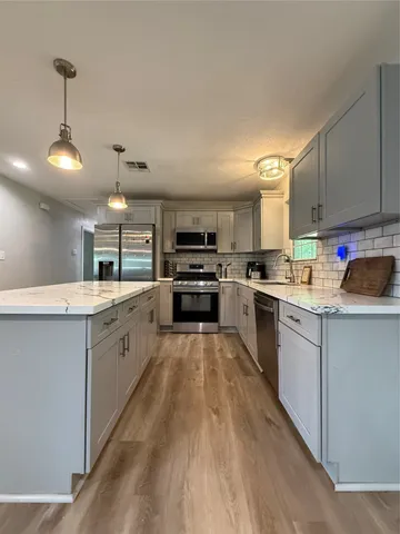 a kitchen with granite countertop a stove top oven a sink a counter space and cabinets