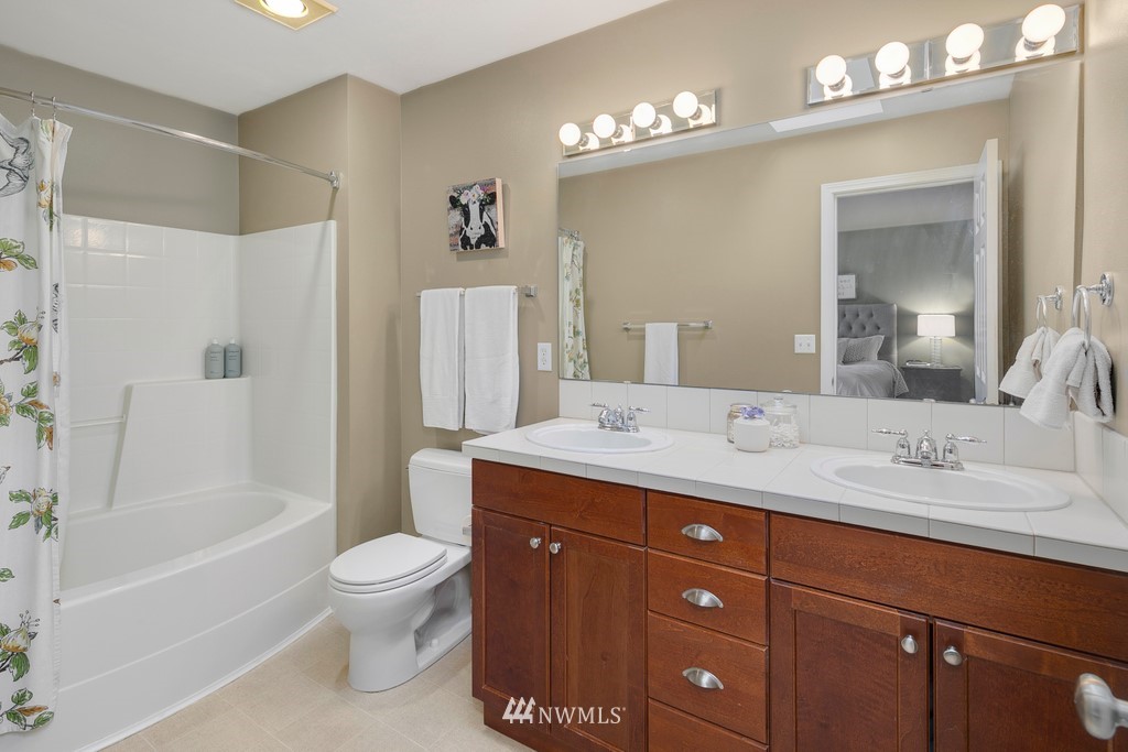 2425 194th Street Southeast, Unit 40 Bothell, WA 98012 - Photo 15 of 20 a bathroom with a granite countertop toilet sink and mirror