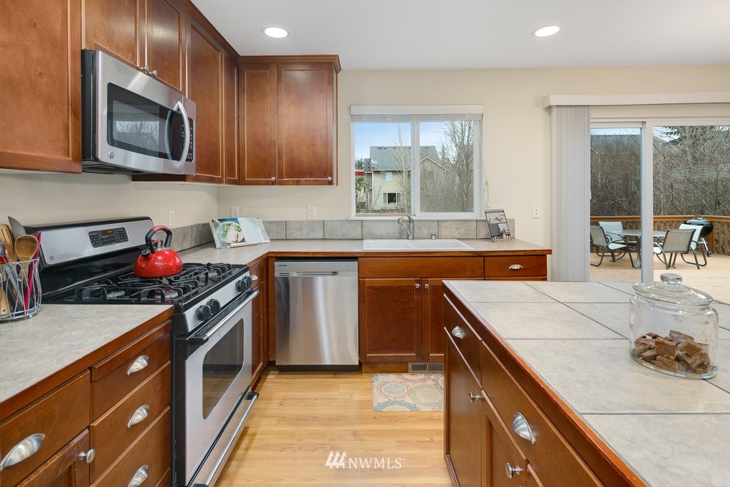 2425 194th Street Southeast, Unit 40 Bothell, WA 98012 - Photo 6 of 20 a kitchen with stainless steel appliances granite countertop wooden cabinets stove top oven and sink