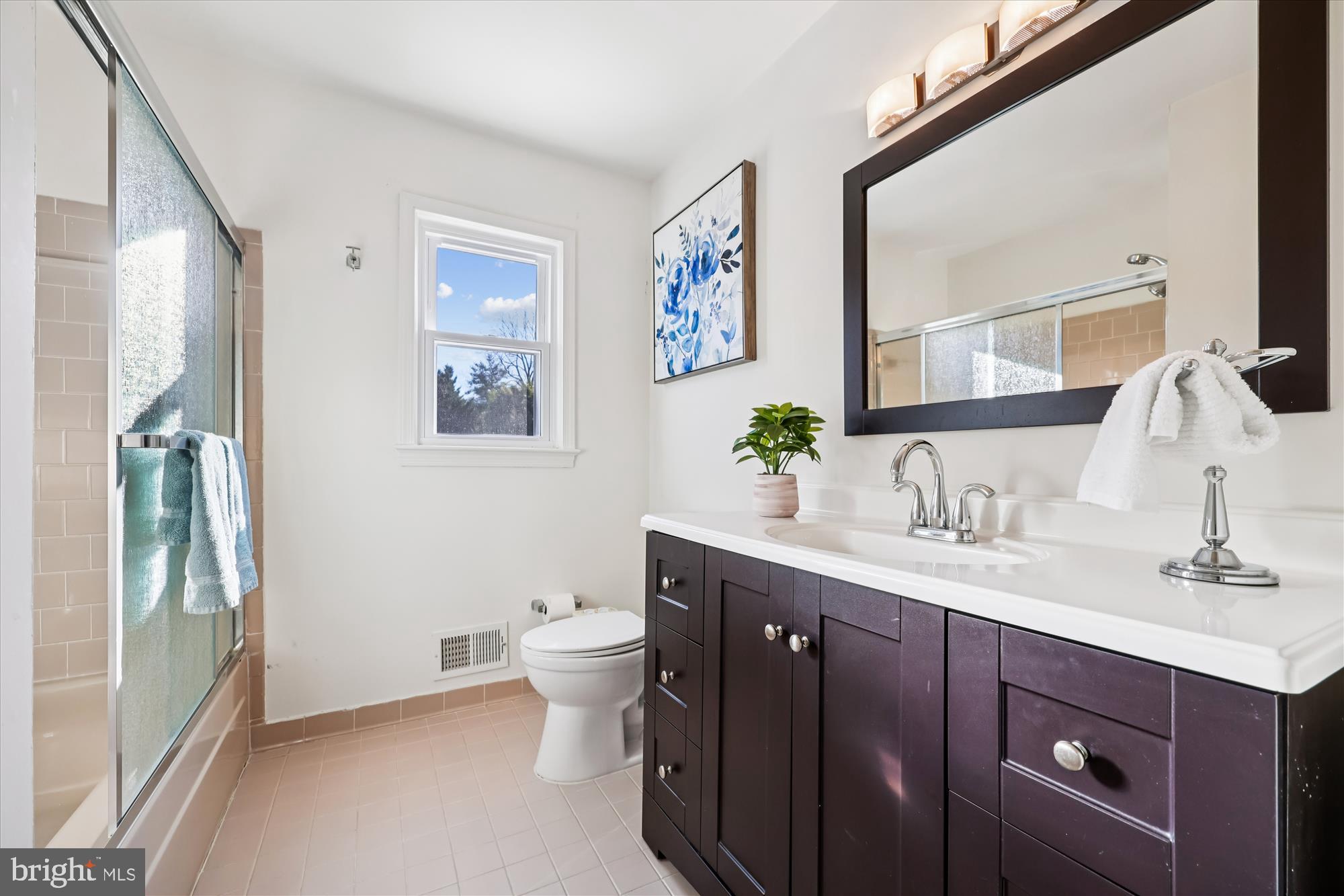 9304 Bells Mill Road Potomac, MD 20854 - Photo 42 of 74 a spacious bathroom with a granite countertop sink and a mirror
