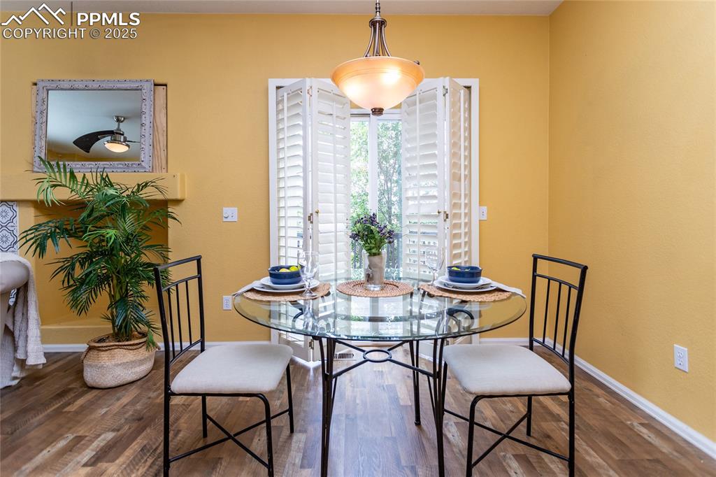 6815 Anchor Point Colorado Springs, CO 80922 - Photo 11 of 46 a view of a dining room with furniture and wooden floor